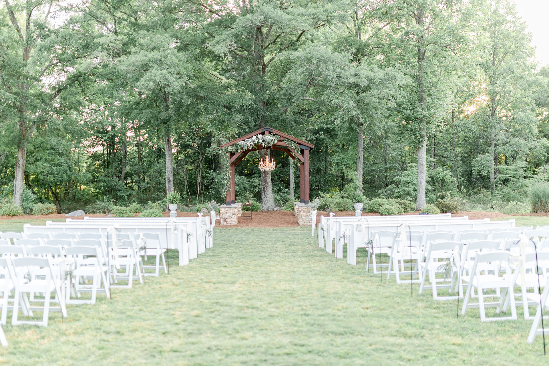outdoor wedding venue setup with chairs and arbor