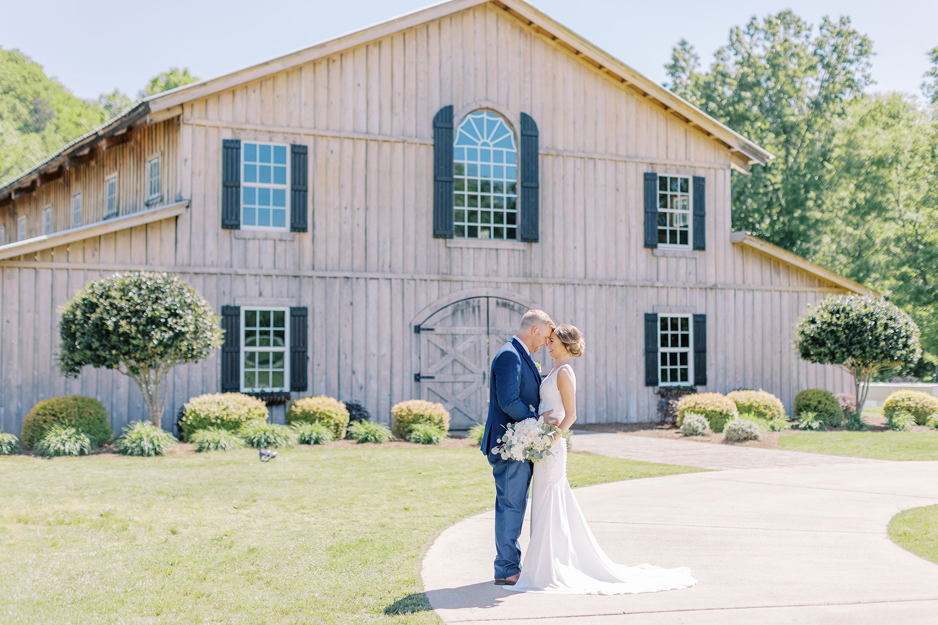 married couple looking at each other in front of barn