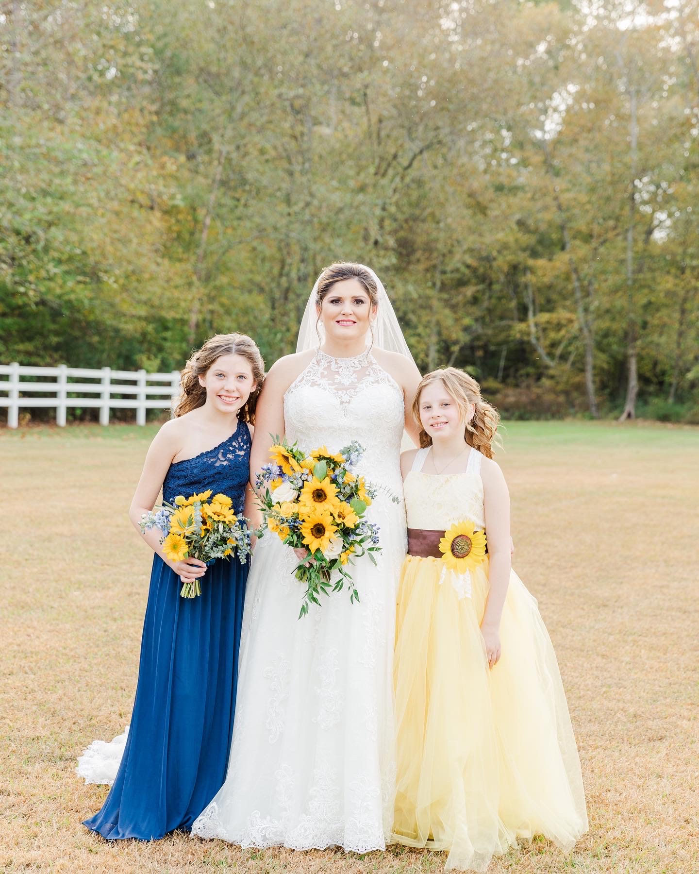 smiling bride with junior bridesmaids sunflower bouquets